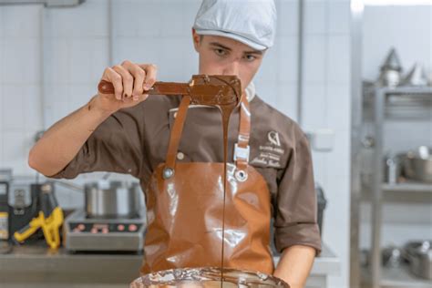 Jeune apprenti confiseur travaillant avec des moules à chocolat