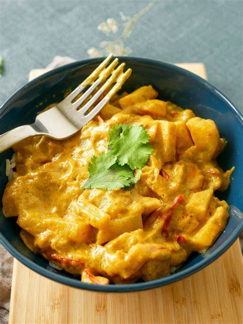 Image d’un plat de poulet au curry crumble bien doré et nappé de sauce au lait de coco