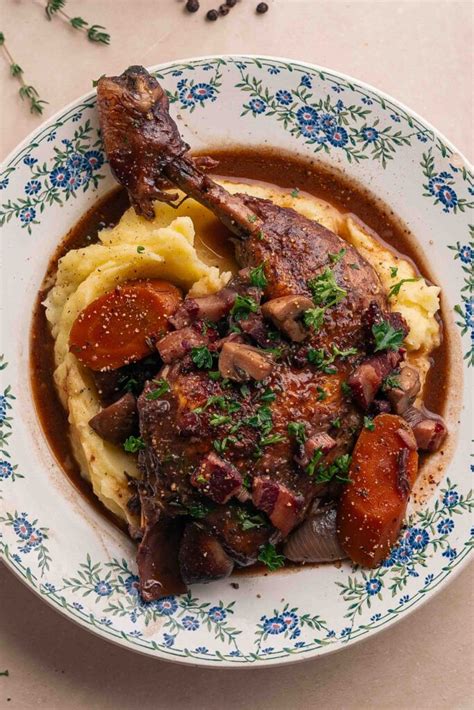 Assiette de Coq au Porc servie avec une purée de pommes de terre et une salade verte