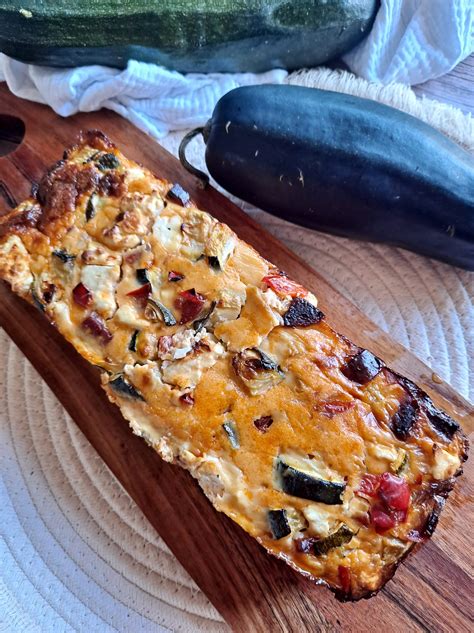Tranche de flan courgettes & chorizo sur une assiette, avec une salade verte