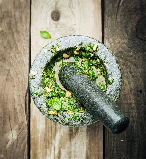 Mortier et pilon avec des ingrédients de pesto