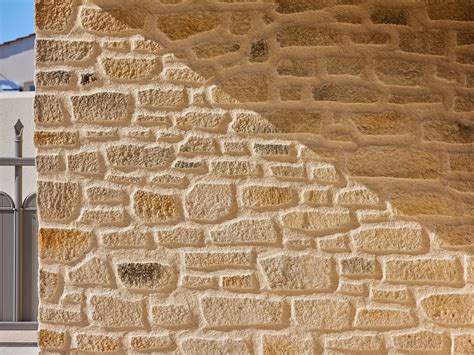 Artisan sculptant un crépi imitation pierre