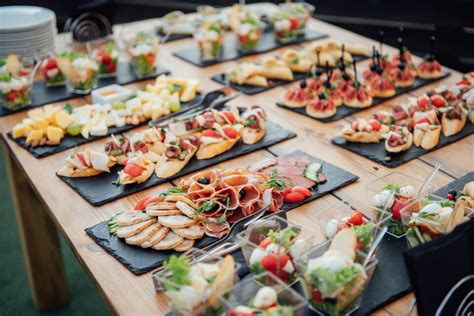 Un buffet avec des plats présentés sur des plateaux et assiettes en ardoise et en mélamine aspect ardoise