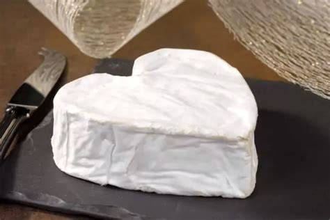 Illustration cohérente d’un Neufchâtel en forme de cœur et sa croûte fleurie, avec un détail sur le duvet blanc et l’intérieur fondant