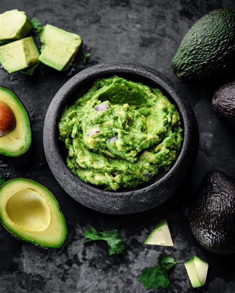 Préparation d'un guacamole frais avec des avocats, oignons et poivrons