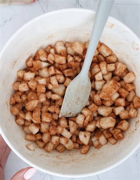 Poires coupées en dés dans un saladier avec du sucre et de la cannelle