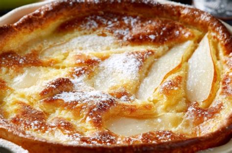Clafoutis aux poires servi en part, décoré de sucre glace