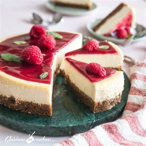 Une part de cheesecake new-yorkais garnie d'un coulis de framboises et de quelques framboises fraîches.