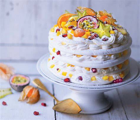 Montage final de la pavlova avec fruits exotiques et chantilly