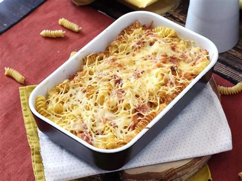 Plat à gratin rempli de couches alternées de pâtes et de préparation à la chair à saucisse, prêt à être enfourné