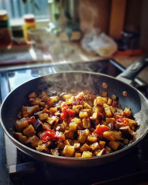 Dés d'aubergines et oignons mijotant dans une poêle