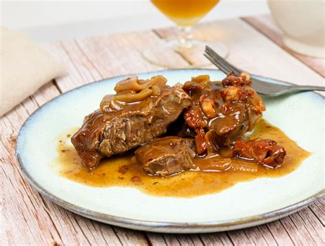 Assiette de joues de porc au cidre et miel servie avec des airelles et du persil