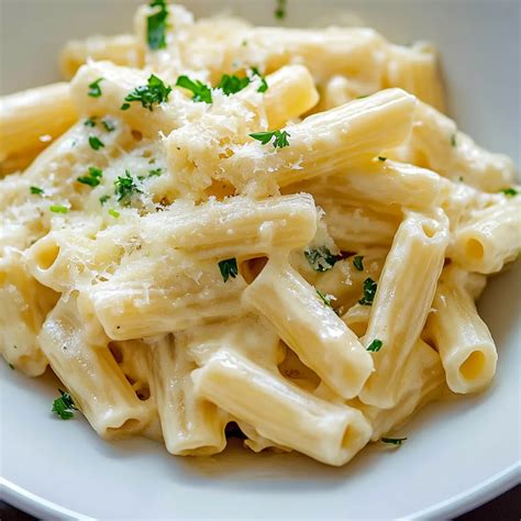 Bol de pâtes crémeuses avec des légumes et du fromage fondu