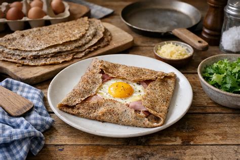 Une photo illustrative montrant des pancakes sarrasin dorés dans une poêle et servis avec topping salé