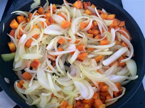 Mélange d'oignons, carottes et bouquet garni dans une poêle