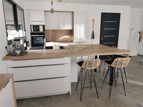 Plan de travail en bois clair contrastant avec des meubles de cuisine blancs