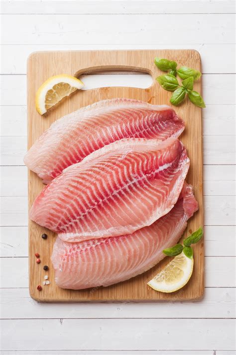 Filets de poisson cru sur une planche à découper