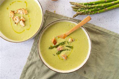 Bol de velouté d'asperges garni de crème et de têtes d'asperges