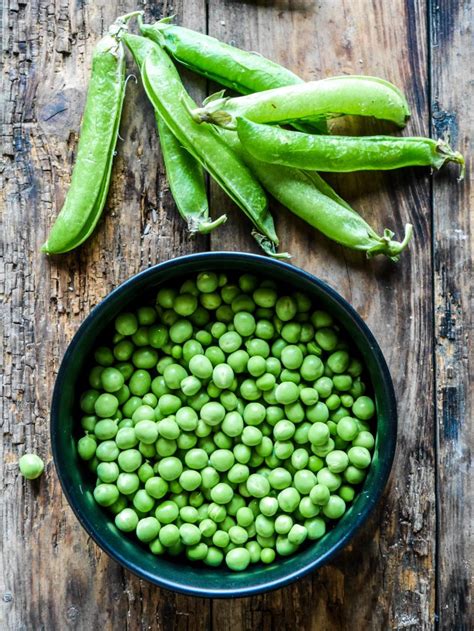 Des petits pois verts brillants dans leur cosse