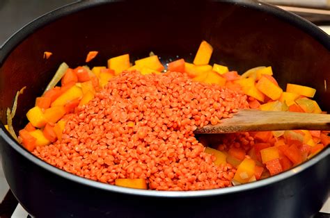 Bol de lentilles corail avec des légumes et des rondelles de saucisse