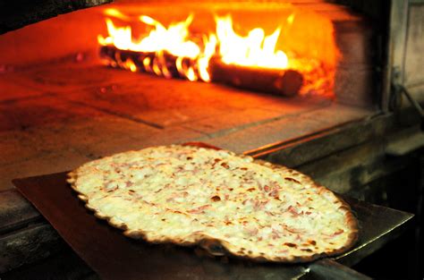 Une tarte flambée dorée sortant du four
