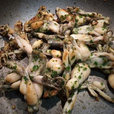 Cuisses de grenouilles dans une poêle avec de la crème et de la persillade