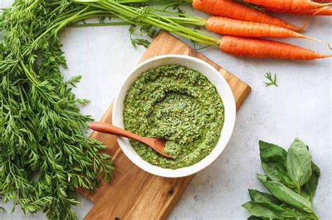 Ingrédients pour le pesto de fanes de carottes disposés sur une table
