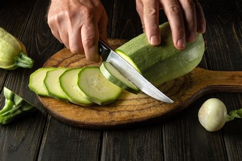 Une personne coupant des courgettes en gros morceaux