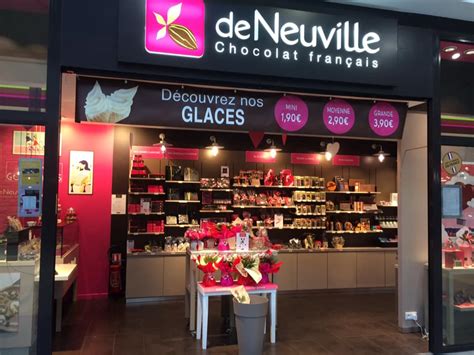 Vitrine d'une chocolaterie De Neuville avec des boîtes élégantes