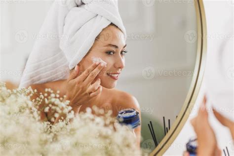 Femme appliquant une crème sur son visage