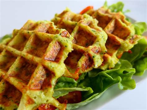 Enfant souriant mangeant une gaufre aux courgettes