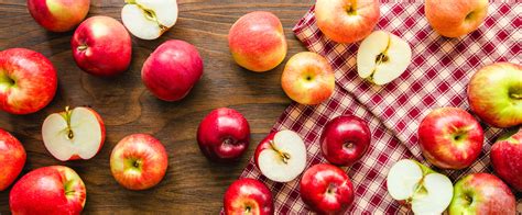 Une variété de pommes colorées disposées sur une planche en bois