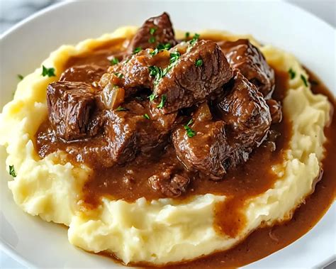 Une assiette de bœuf braisé servi avec une purée de pommes de terre