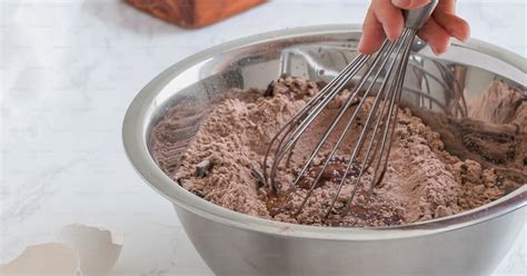 Personne mélangeant du chocolat et de la crème avec une maryse