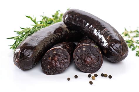 Un charcutier remplissant un boyau avec une mêlée de boudin noir