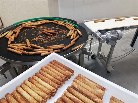 Infographie montrant les étapes d'assemblage d'une barre Lion : empilement de gaufrettes, ajout de caramel, refroidissement, enrobage de chocolat.