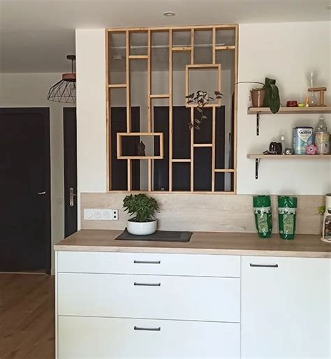 Cuisine ouverte sur salon délimitée par une claustra en bois