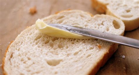 Une assiette avec du pain beurré et une tartine de margarine