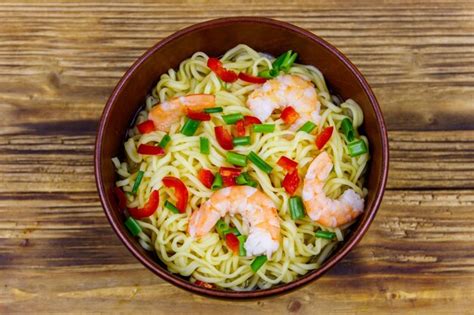 Composition d'un bol de nouilles chinoises colorées avec des légumes frais et des crevettes