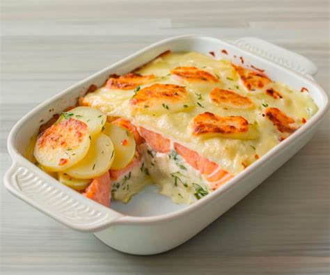 Plat à gratin avec des couches de pommes de terre, saumon et oignons