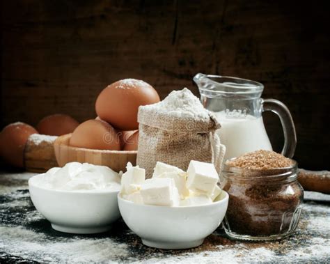 Un assortiment d'ingrédients frais : farine, lait, œufs, beurre, levure, sucre, et un pot de Nutella.