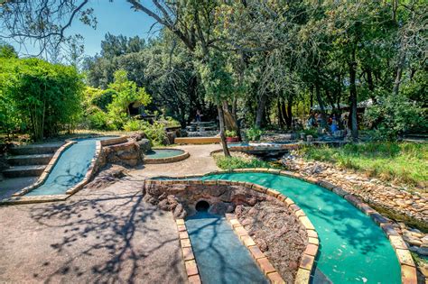 Personnes jouant au mini-golf dans un cadre verdoyant près de la mer