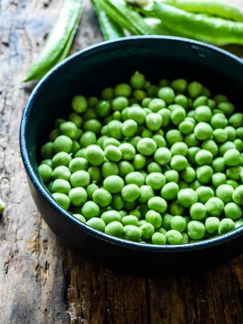 Gros plan sur des petits pois frais dans leur cosse