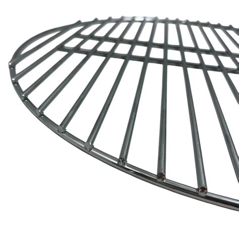 Gros plan d'une grille foyère en acier avec des braises