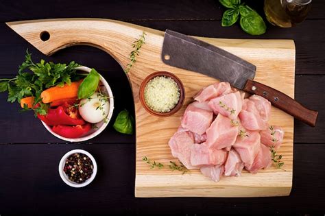 Filets de pigeon crus sur une planche à découper avec des herbes