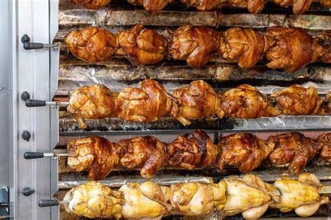 Photo d’un poulet prêt à être cuisiné sur rôtissoire verticale Weber