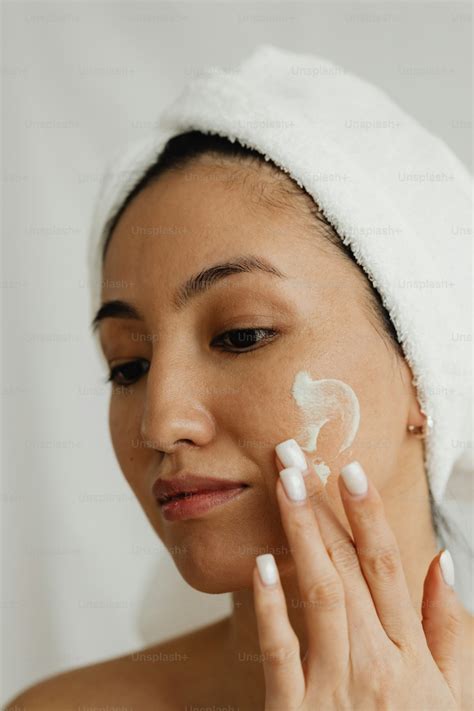 Une femme appliquant une crème de nuit sur son visage