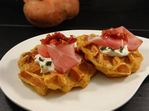 Photo montrant une assiette de gaufres salées à la patate douce, garnies d’avocat et de légumes