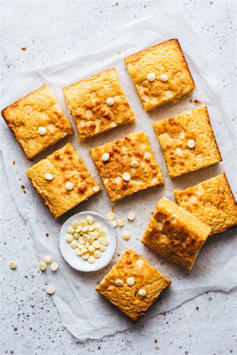 Gros plan sur un brownie au chocolat blanc coupé, révélant une texture moelleuse et des éclats de praliné