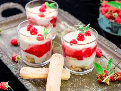 Plusieurs verrines de tiramisu aux framboises disposées joliment sur une table